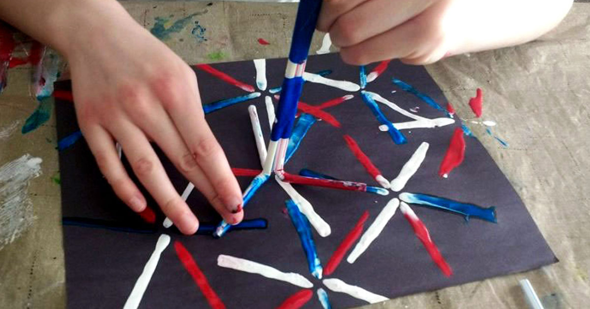 person using straws to paint fireworks
