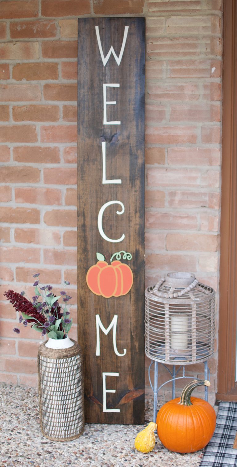 the word Welcome painted on a tall board with a fall theme