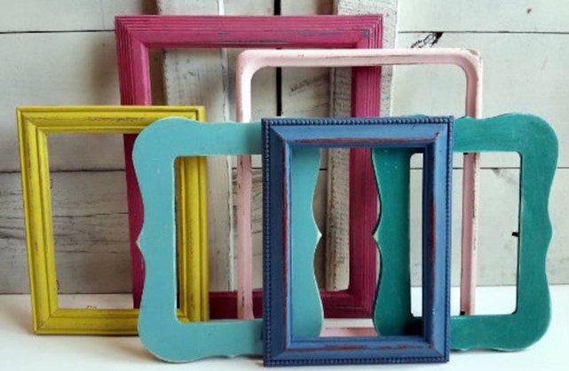 a pile of colorfully painted picture frames