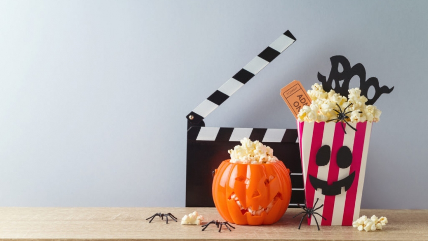 a halloween themed movie display with popcorn and a movie clapboard