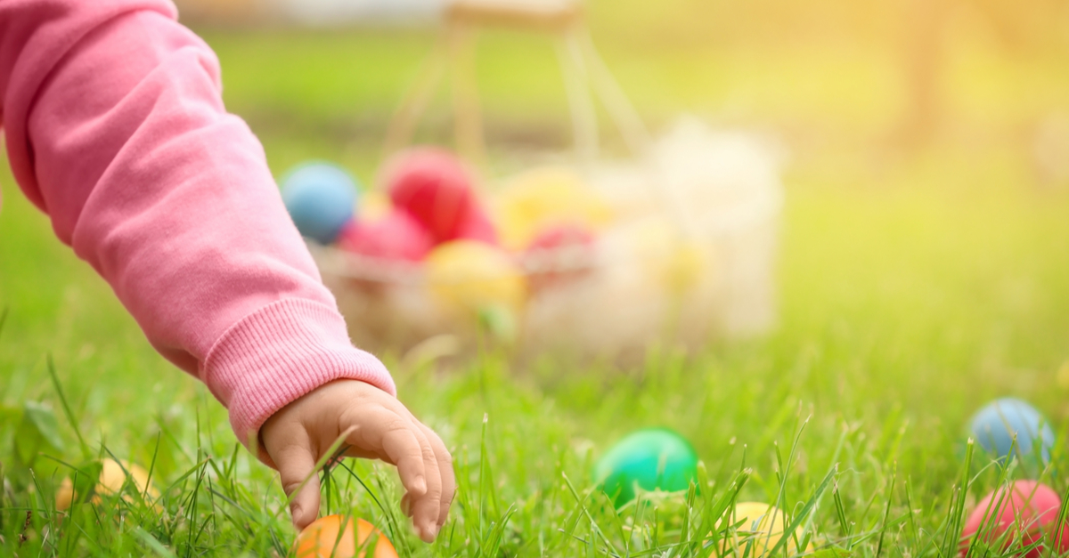 child hunting for easter eggs in a grassy field
