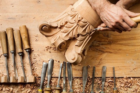 person carving a design into wood