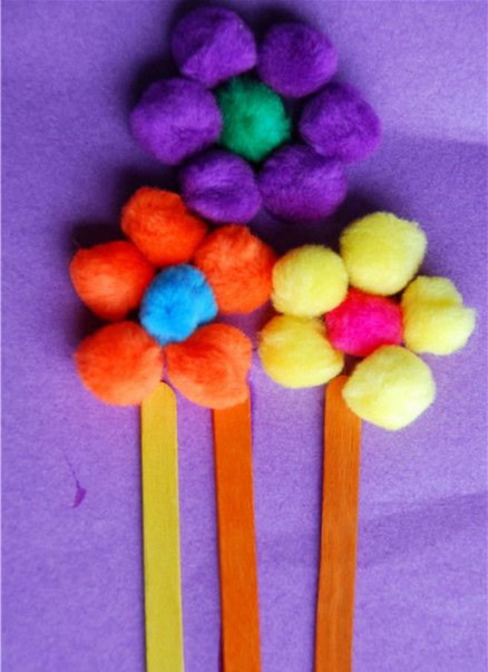 construction paper bookmark with flowers made with pom poms and craft sticks