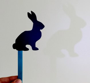 a shadow made by a paper rabbit on a craft stick