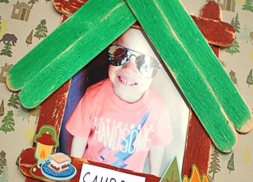 a picture frame shaped like a house made with craft sticks