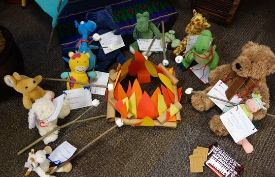 stuffed animals roasting marshmallows by a construction paper campfire