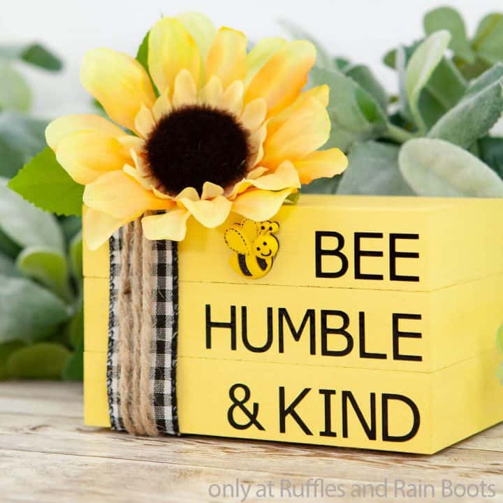 craft of blocks of wood stacked like books with a sunflower and a bee; says bee humble and kind