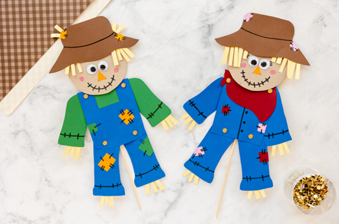2 scarecrows made out of colorful construction paper