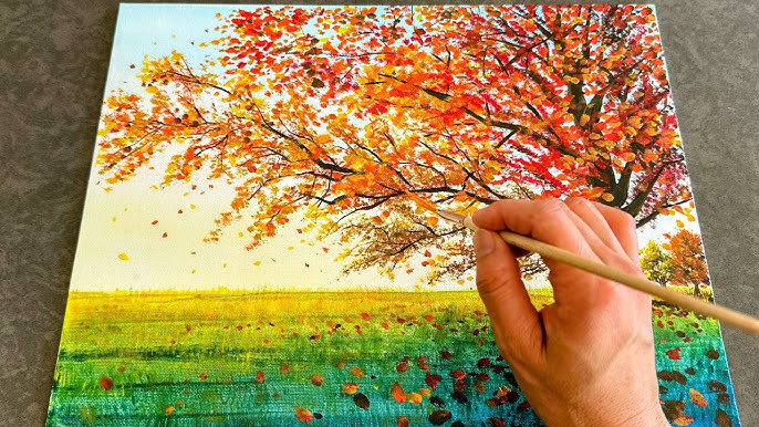 hand holding brush painting a tree with fall leaves