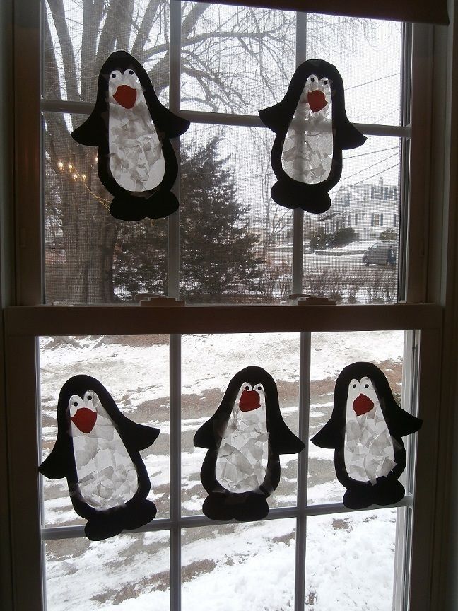 Window holding 5 penguin sun catchers made using paper and wax paper