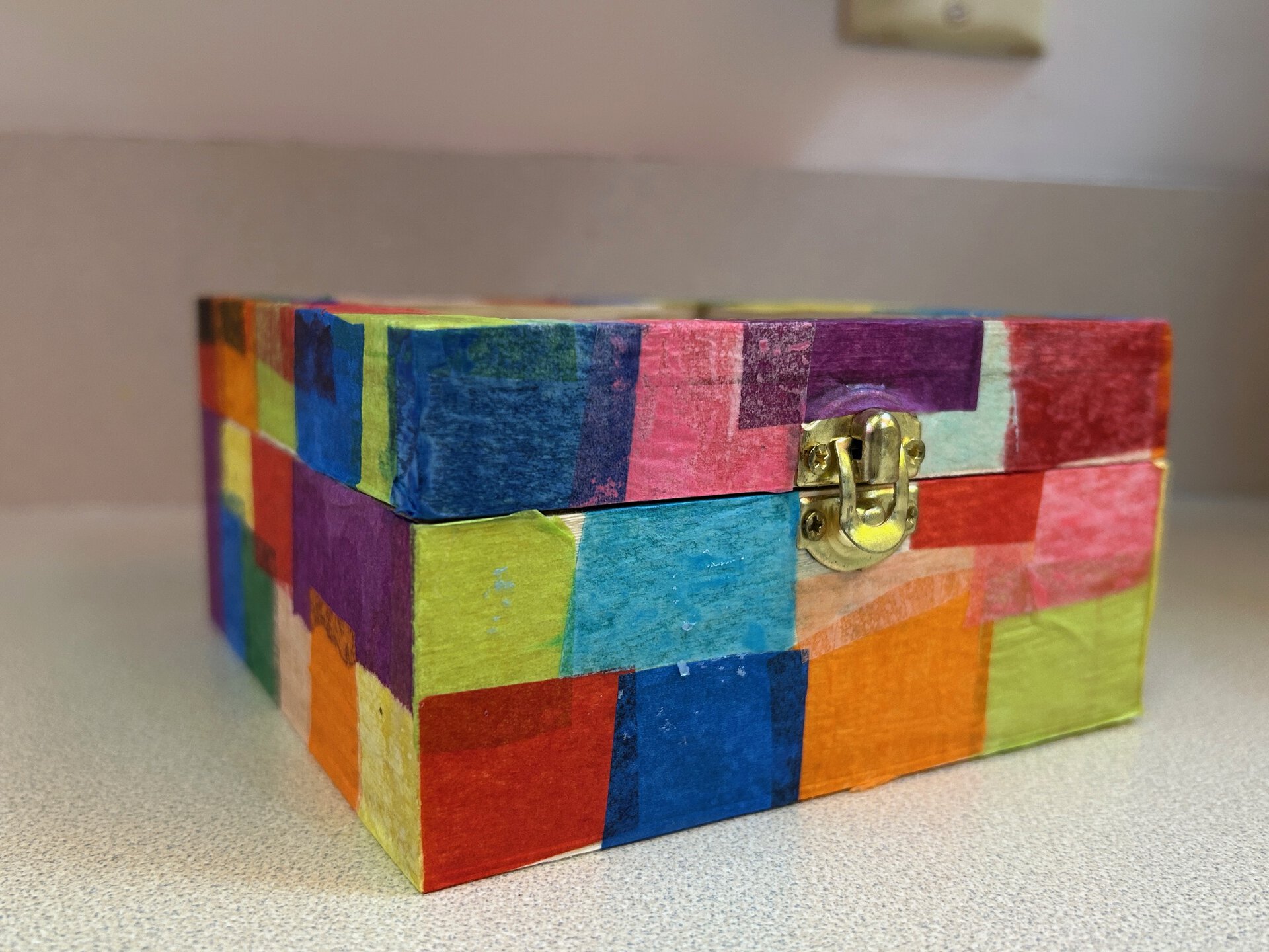 wood box with tissue paper squares glued to it