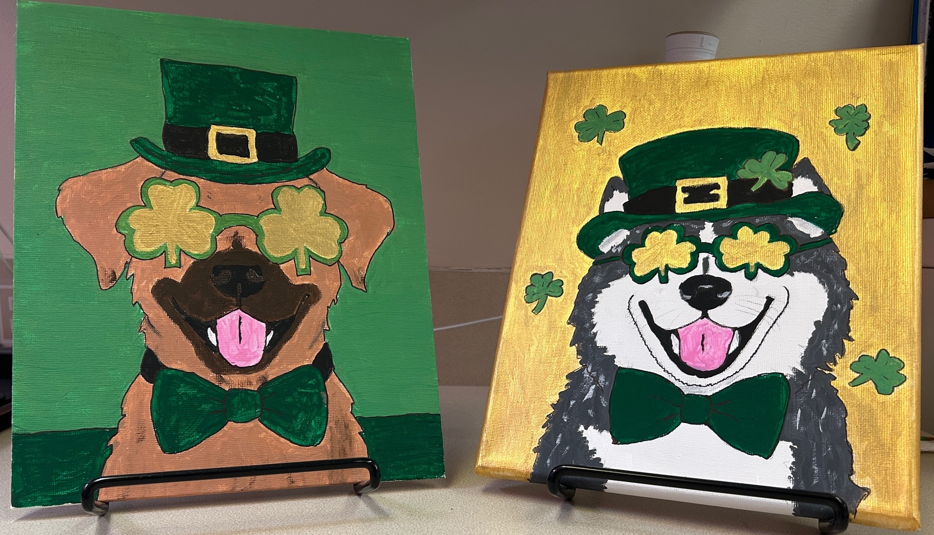 Two paintings of dogs dressed in leprechaun hats and green bow ties.