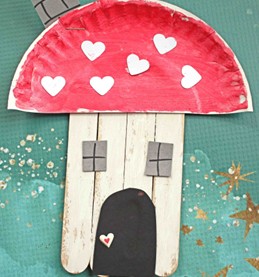 craft sticks glued together in the shape of a rectangle. paper windows and a paper door glued on with a paper plate half painted and glued on as the roof