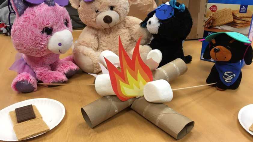 stuffed animals set up around a fake campfire and fake smores