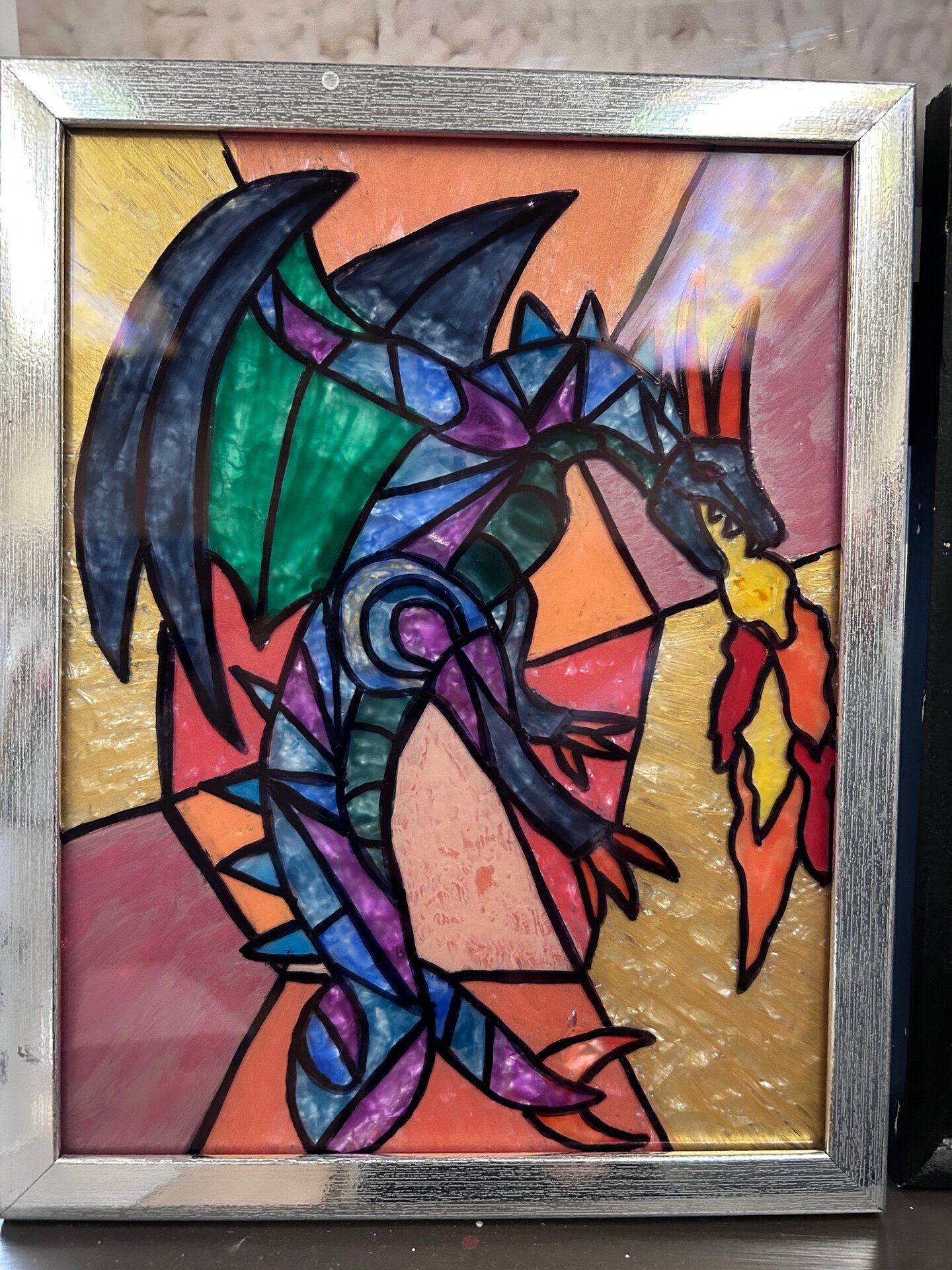 painted glass picture of a dragon in various colors
