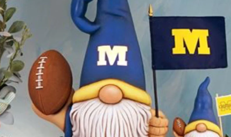Ceramic gnome with blue hat holding a flag and a football