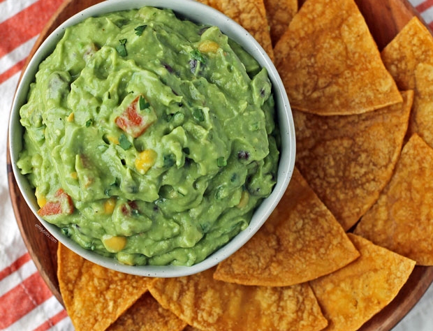 a bowl of guacamole surrounded by tortilla chips