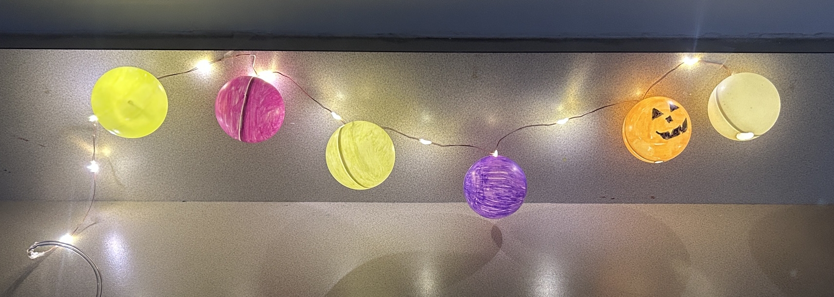 6 colored ping pong balls on string lights